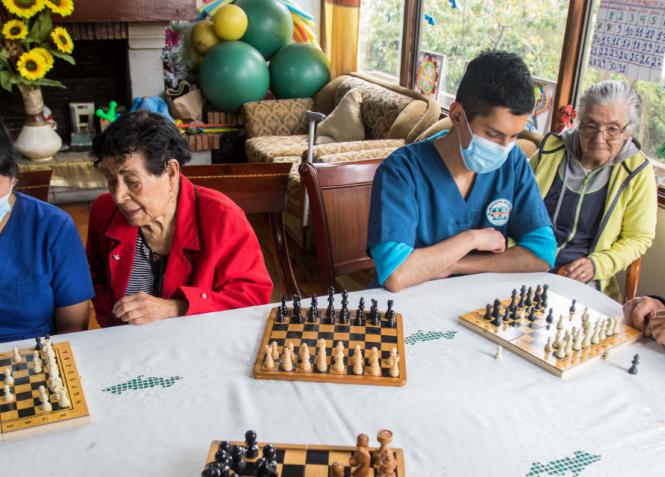 Cuando juegan ajedrez los adultos mayores del Centro Geriátrico Fuerza de Roble están acompañados de enfermeros y cuidadores.