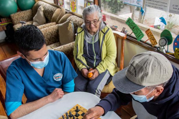 Personas de la tercera edad juegan ajedrez en un centro especializado para su cuidado.