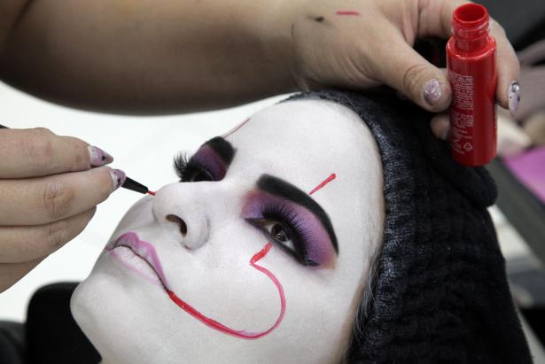 Con un pincel fino y pintura facial, traza líneas rojas de la boca a las cejas. Foto: Patricio Terán/FAMILIA